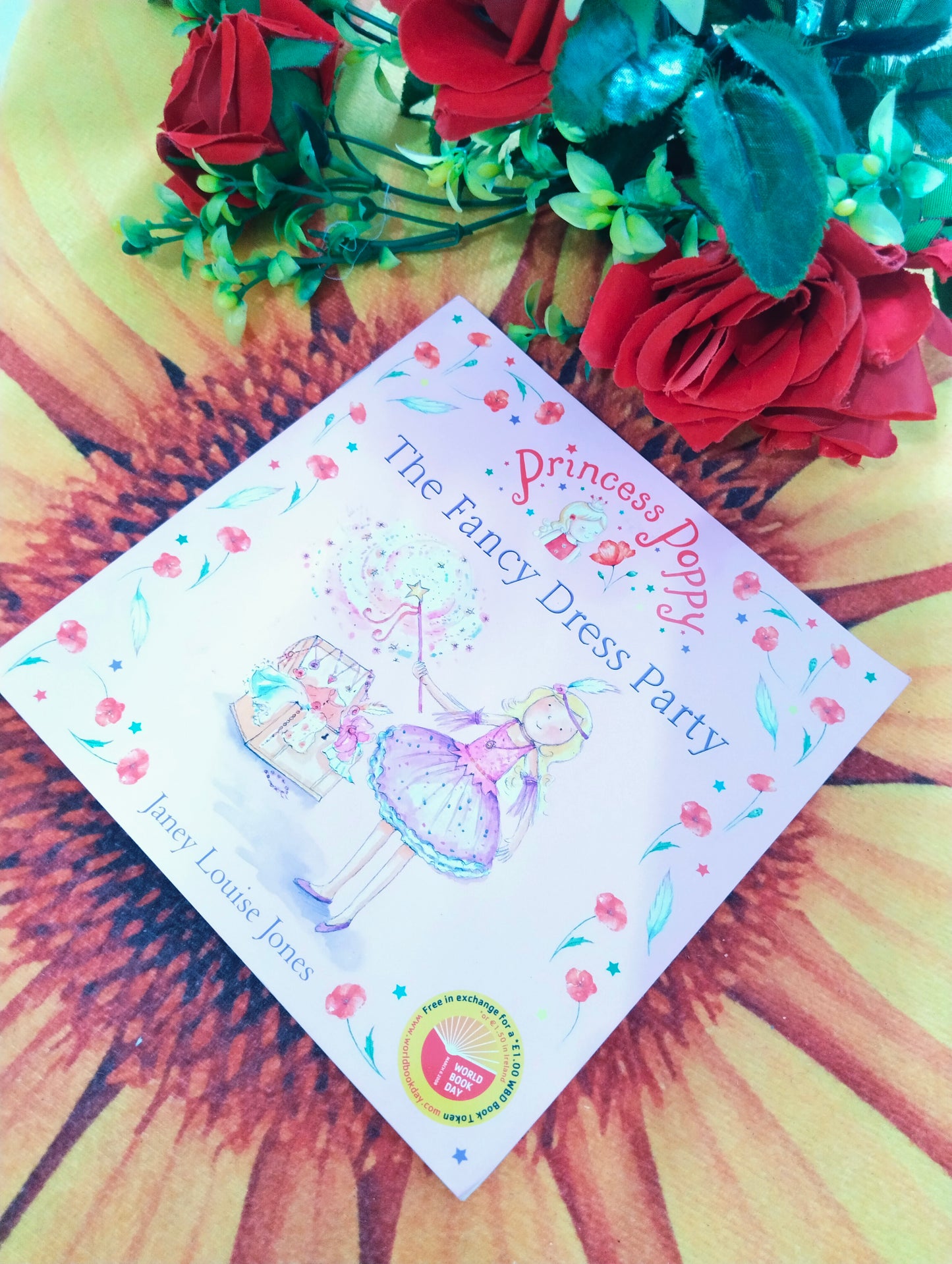 A children's book titled 'The Fancy Dress Party' by Janez Louise Jones, featuring a whimsical illustration of a girl in a purple dress, styled on a yellow sunflower print background with red roses.